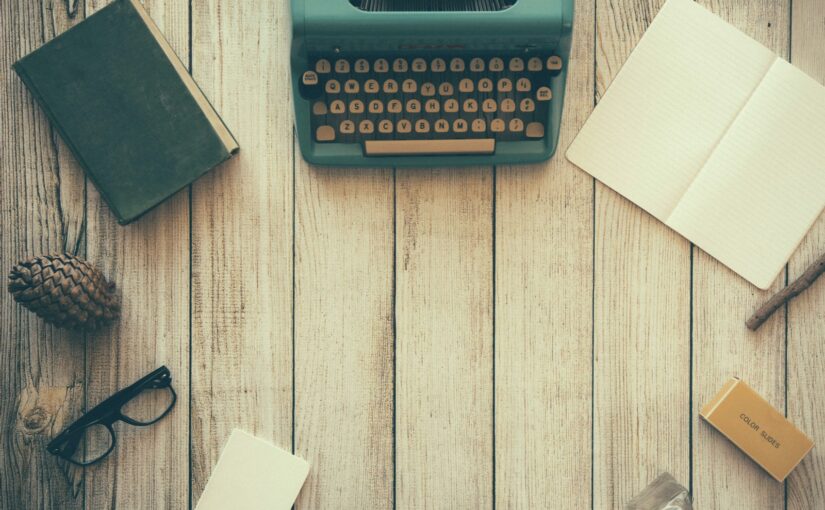 vintage teal typewriter beside book